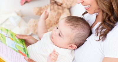 Joyful mother showing images in a book to her cute little son